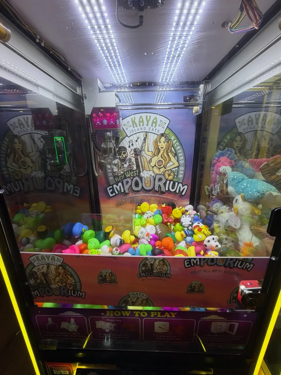 Key West Empourium themed claw machine with colorful graphics and prizes
